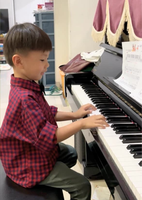 A young student practicing a song at the piano